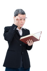 Old asian woman reading book having problem with her eyes