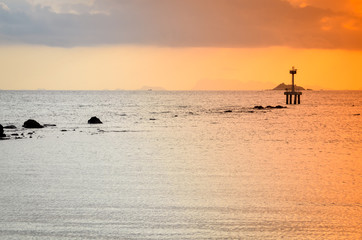 Fototapeta premium sunset over ocean with small boat silhouette