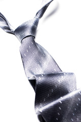 Gray spotted man's knotted tie over white. Isolate.