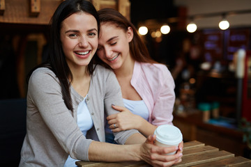 Ecstatic girls having drinks in cafe