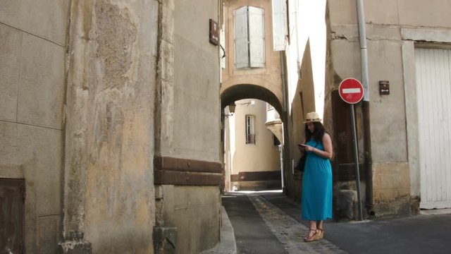 A woman in a blue dress walking through the old town
