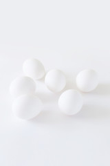 Fototapeta na wymiar Easter decoration minimalistic white chicken eggs lying on a white background, daylight, vertical image