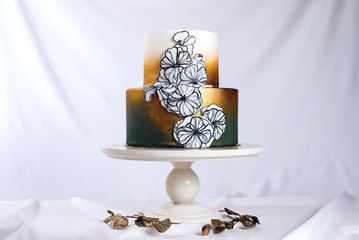 wedding cake decorated gold, green gradient with hand drawn flowers