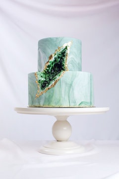 Wedding cake decorated like stone marble with emeralds in cut