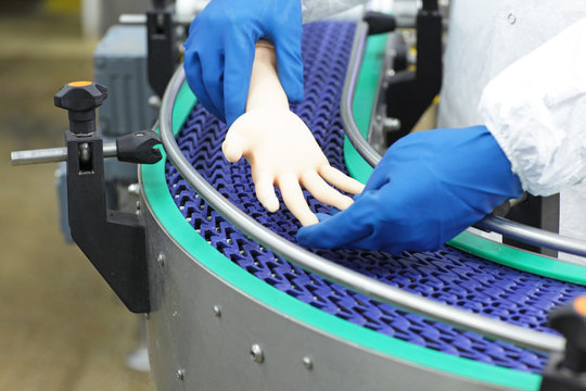 technician at conveyor belt controlling artificial bionic hand . a concept of spare body parts 