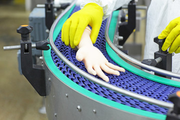 technician at conveyor belt controlling artificial bionic hand . a concept of spare body parts mass...