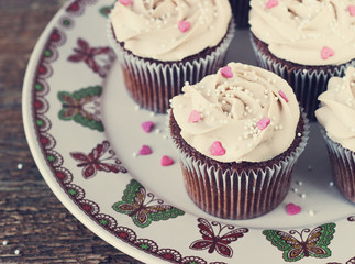 Chocolate cupcakes decorated with cream rose hearts toning