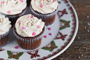 Chocolate cupcakes decorated with cream rose hearts
