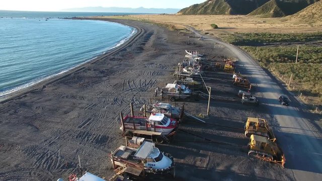 Aerial view of fishing boats and tractors on Ngawi beach, New Zealand