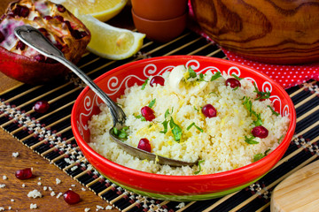 Couscous in oriental style with grains of pomegranate, lemon zest and butter