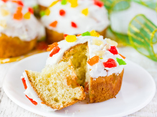 Easter cupcakes with icing and colorful candied fruits sliced on white wooden table