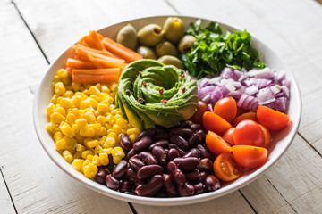 Vegan Buddha bowl. Mixed vegetable salad. Healthy meal concept. White wooden background.