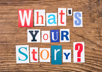 Question "What's your story?" in cut out magazine letters on wooden background 