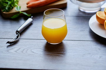 Orange juice in a glass and delicious carrot.