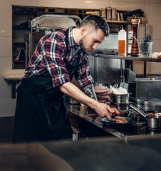 Cheef cook prepairing a meat on a kitchen.