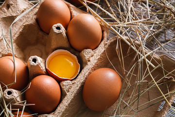 Brown eggs carton. Healthy food background. Yellow yolk