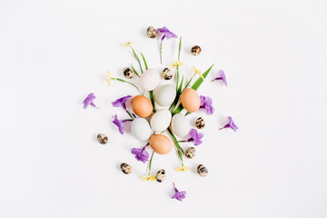 Easter eggs, quail eggs, yellow and purple flowers on white background. Flat lay, top view. Traditional spring concept. Easter concept.