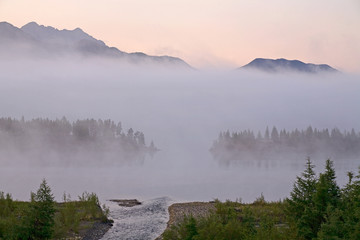 Morning fog over a mountain lake. Lake Dabir. Yakutia. Russia.