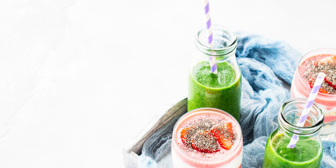 Healthy food concept green smoothie yogurt strawberries chia seeds breakfast on white gray tray blue textile. Fruit Vegetable juice glass bottle