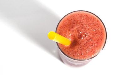A glass of red healthy juice isolated over a white background