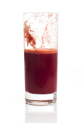 A glass of half full red healthy juice isolated over a white background