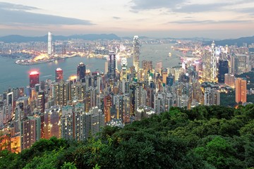 Night scenery of Hong Kong viewed from Victoria Peak with city skyline of crowded skyscrapers along Victoria Harbour and Kowloon area across seaport ~ Beautiful cityscape of Hong Kong at sunset