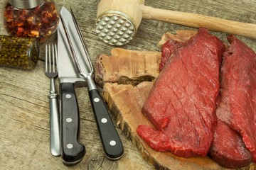 Preparing for grilling. Raw beef on a wooden board. Homework steak.
