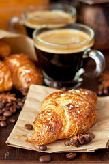 Espresso coffee in glass mug and croissant