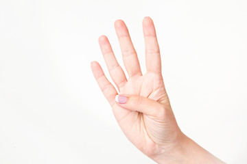 Closeup of caucasian female caucasian hand isolated on white background. Young woman shows 4 fingers while counting. Horizontal color image.