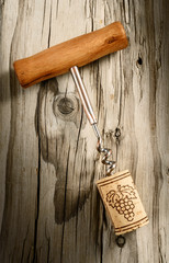 corkscrew with cork on aged wood