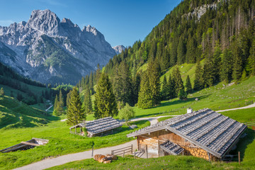 Idyllic mountain scenery with traditional mountain chalets in the Alps in springtime