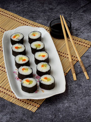 Sushi on white plate, grey background. Traditional Asian food. Diet healthy food. Selective focus. Space for text