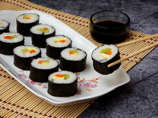 Sushi on white plate, grey background. Traditional Asian food. Diet healthy food. Selective focus. Space for text