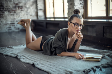 young sexy beauty woman lie home on floor and read book - obrazy, fototapety, plakaty