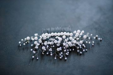 wedding decoration for hair comb in white beads on a dark blue background, close-up of copyspace