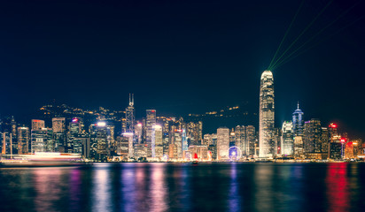 Stunning view of Hong Kong skyline and Victoria harbour seen from Harbour City from where is possible to attend the Symphony of Light, smooth water flowing in the foreground, Hong Kong.