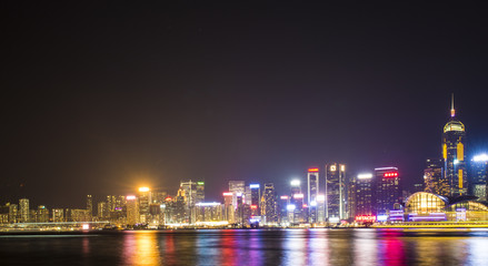 Stunning view of Hong Kong skyline and Victoria harbour seen from Harbour City from where is possible to attend the Symphony of Light, smooth water flowing in the foreground, Hong Kong.