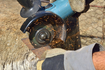 Electric grinder. A man working with electric grinder tool on steel structure, sparks flying