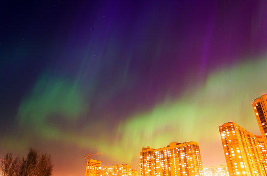 Aurora borealis starry night over the city and houses