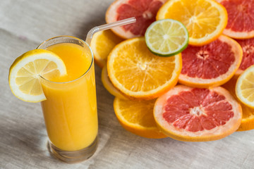 glass of orange juice on a linen background with slices of citrus