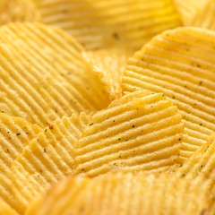 close up rippled natural potato chips with salt and greenery