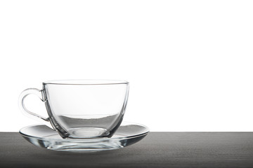 empty transparent tea cup isolated on wooden over white background, mock up
