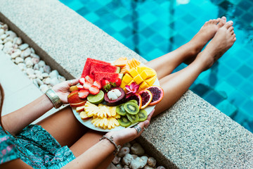 Relaxing with fruits by the pool