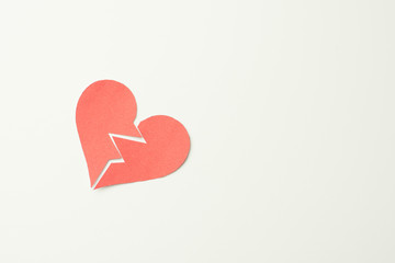 Red paper broken heart on white background