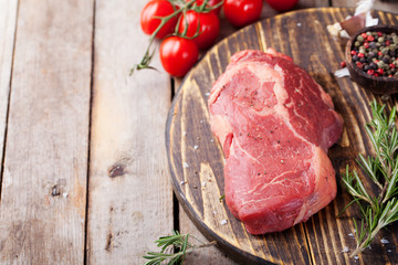 Raw fresh meat Steak on cutting board. Wooden background Copy space