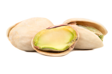 Salted pistachio nuts with a half on a white background closeup