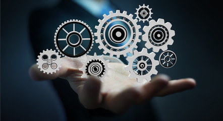 Businessman holding floating gear icons in his hand 3D rendering