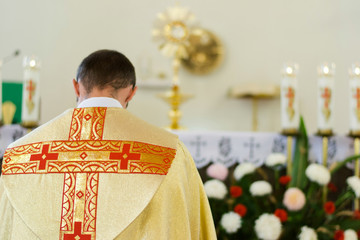 Indoor portrait of Catholic priest from back - obrazy, fototapety, plakaty