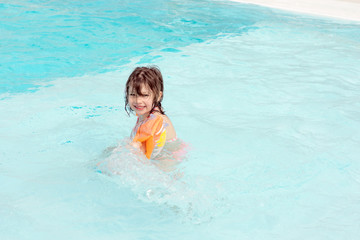 Fototapeta na wymiar jolie jeune fille jouant dans la piscine