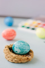 Light blue color easter egg on nest over bright background.